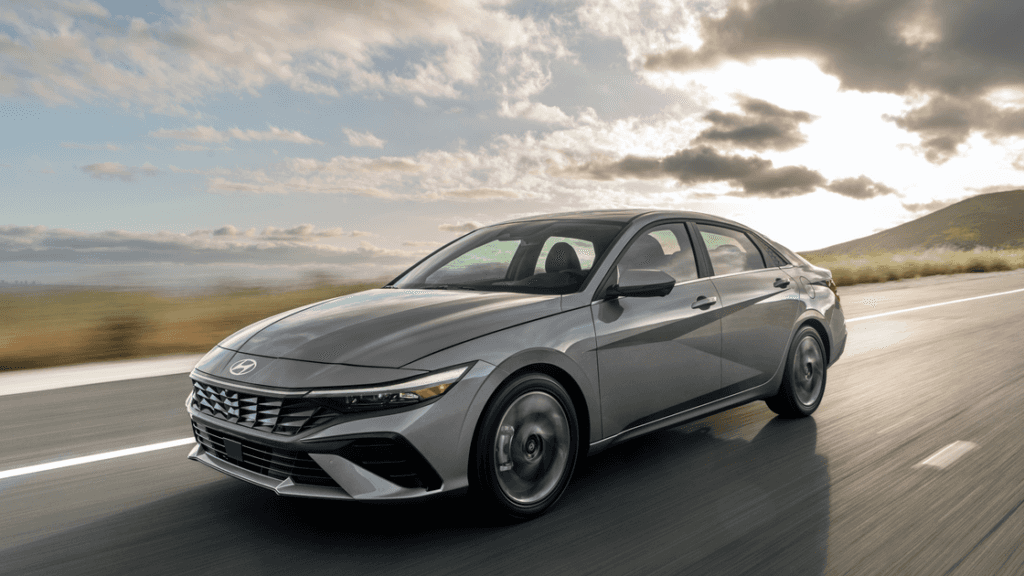 2026 Hyundai Elantra sedan driving on highway with aerodynamic styling and sharp front fascia.