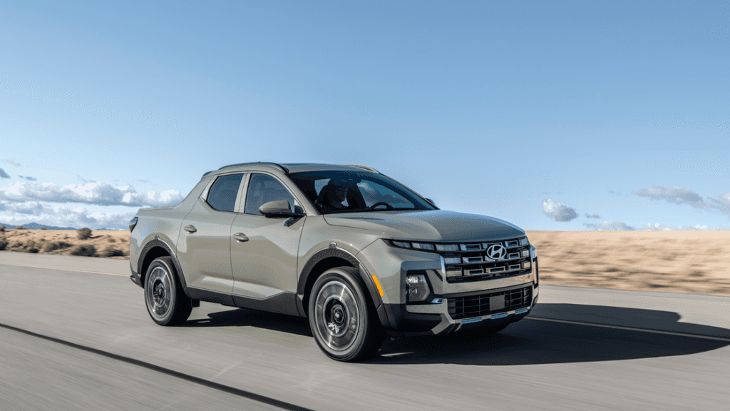 2026 Hyundai Santa Cruz sport adventure truck driving on desert road with bold grille and wheels.