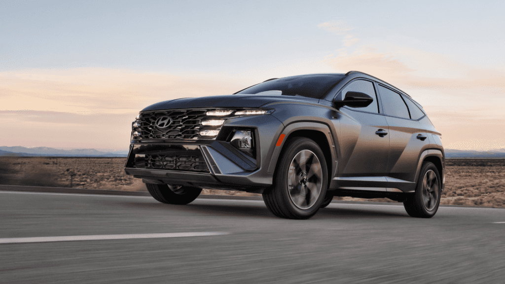2026 Hyundai Tucson SUV driving at dusk showcasing dynamic body lines and aggressive front fascia.