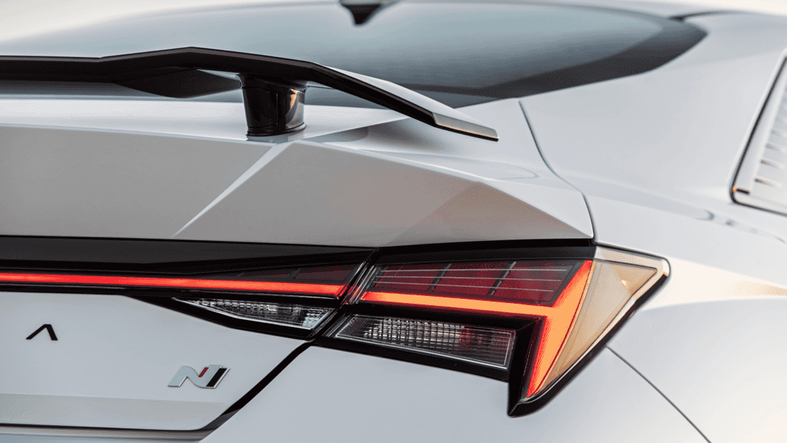 Rear exterior view of the 2026 Hyundai Elantra N highlighting LED taillights, N badging, rear diffuser, and aerodynamic sedan profile.