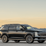 2026 Hyundai Palisade full size SUV side profile in black parked on open road at sunset.