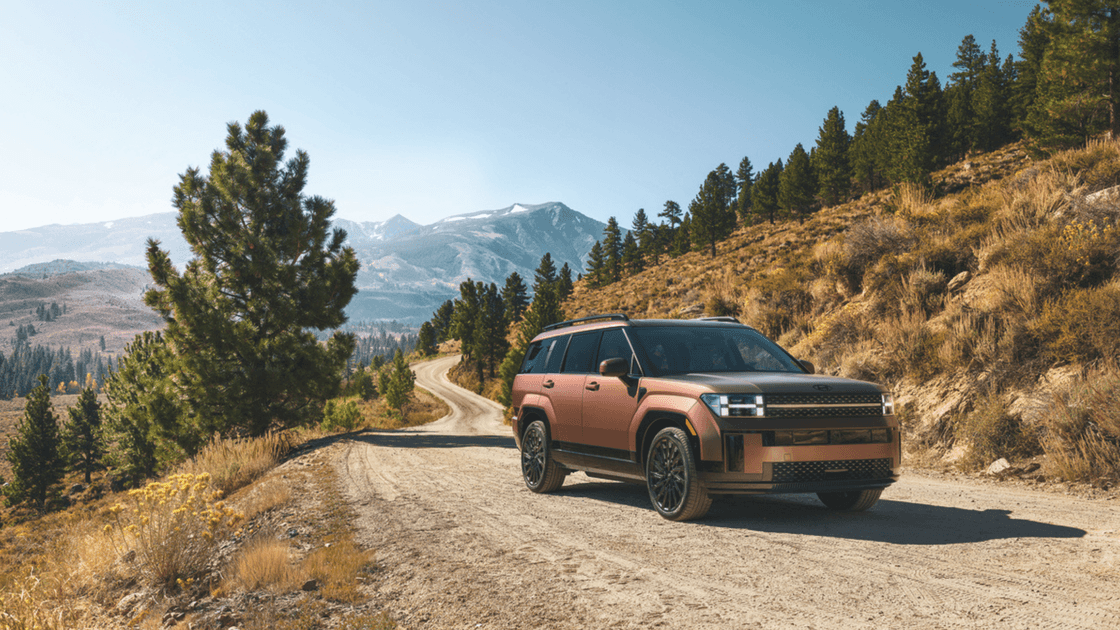 2026 Hyundai Santa Fe Hybrid SUV front three quarter view on mountain dirt road.
