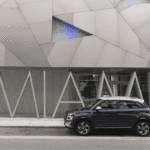 2026 Hyundai Venue subcompact SUV side view parked in front of modern art museum.