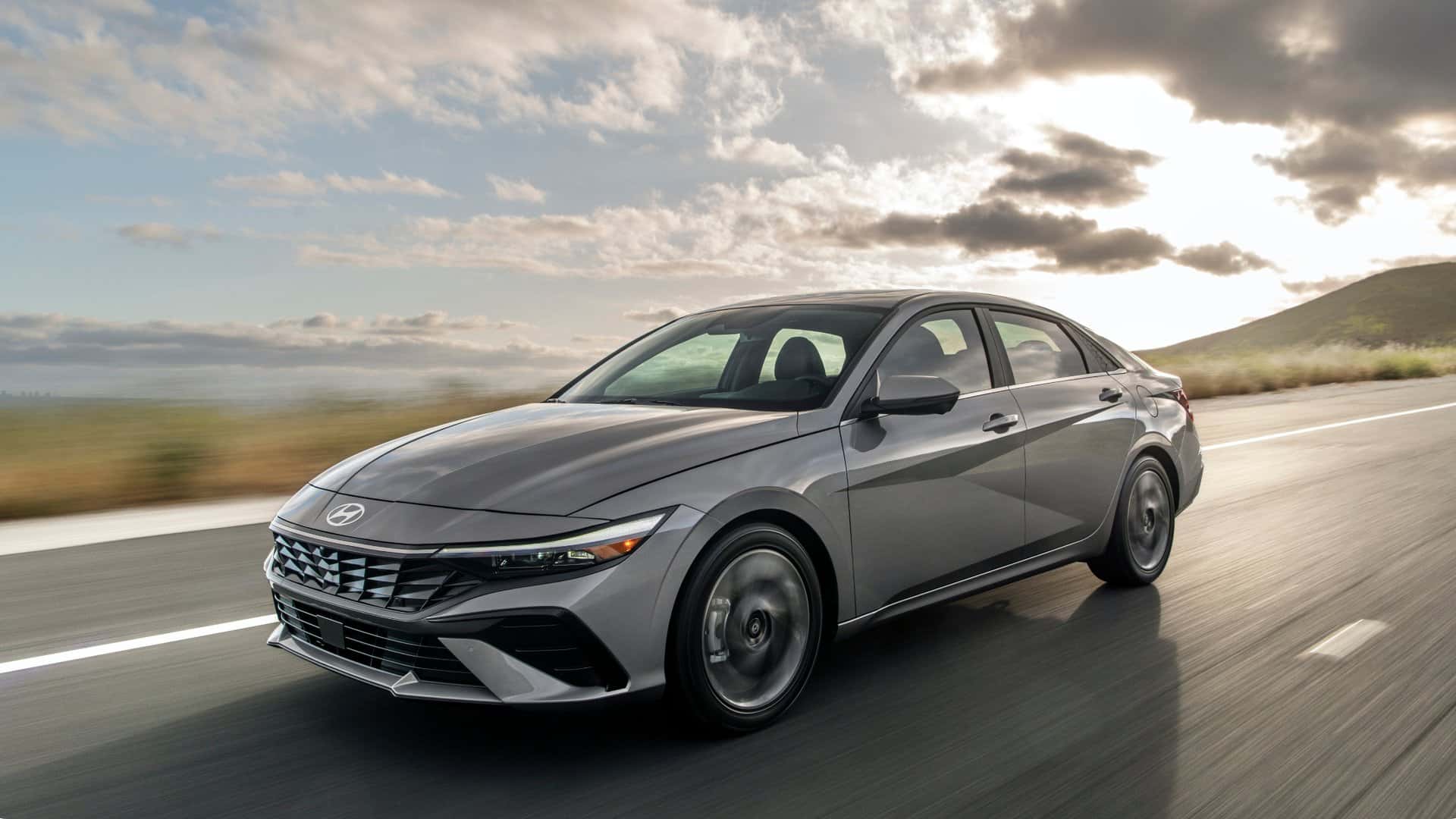 2026 Hyundai Elantra sedan driving on an open highway, showing sleek exterior styling and aerodynamic front design.