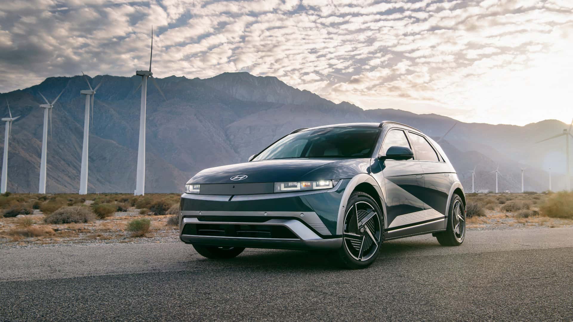 2026 Hyundai IONIQ 5 electric SUV exterior parked near wind turbines, highlighting pixel LED lighting and aerodynamic EV styling.