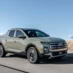 2026 Hyundai Santa Cruz sport adventure truck driving on an open road, featuring rugged styling and compact pickup design.