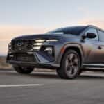 2026 Hyundai Tucson SUV driving on a desert highway, showcasing sharp exterior lines, alloy wheels, and dynamic stance.