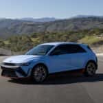2026 Hyundai IONIQ 5 N electric performance hatchback front three quarter view on racetrack showcasing aerodynamic design and sport wheels.