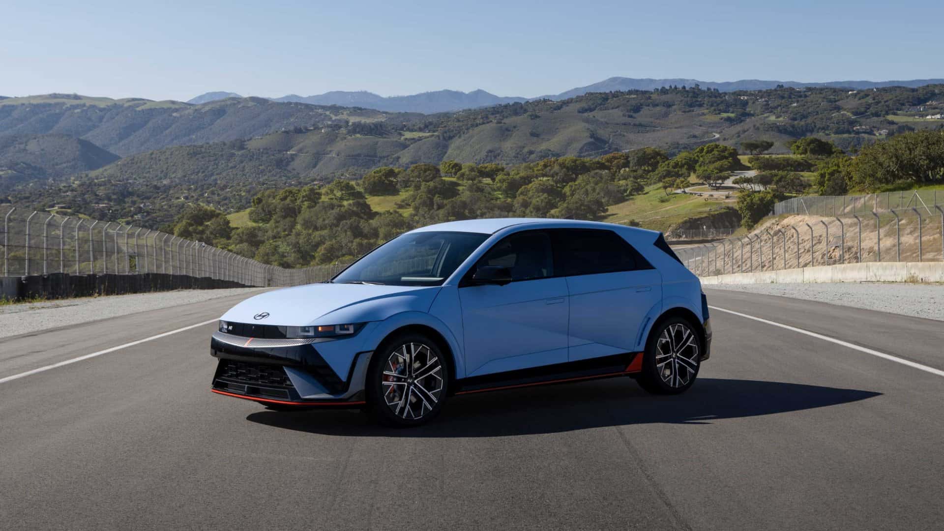 2026 Hyundai IONIQ 5 N electric performance hatchback front three quarter view on racetrack showcasing aerodynamic design and sport wheels.