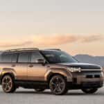 2026 Hyundai Santa Fe Hybrid SUV side profile on desert road at sunset showcasing hybrid efficiency and bold exterior design.