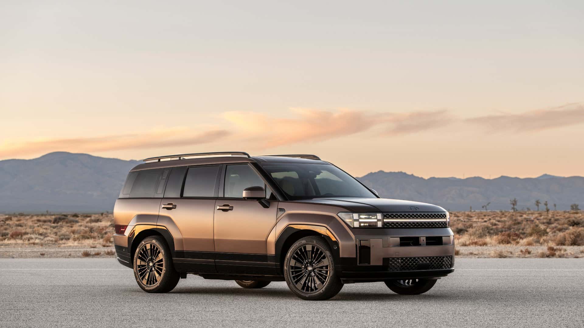 2026 Hyundai Santa Fe Hybrid SUV side profile on desert road at sunset showcasing hybrid efficiency and bold exterior design.