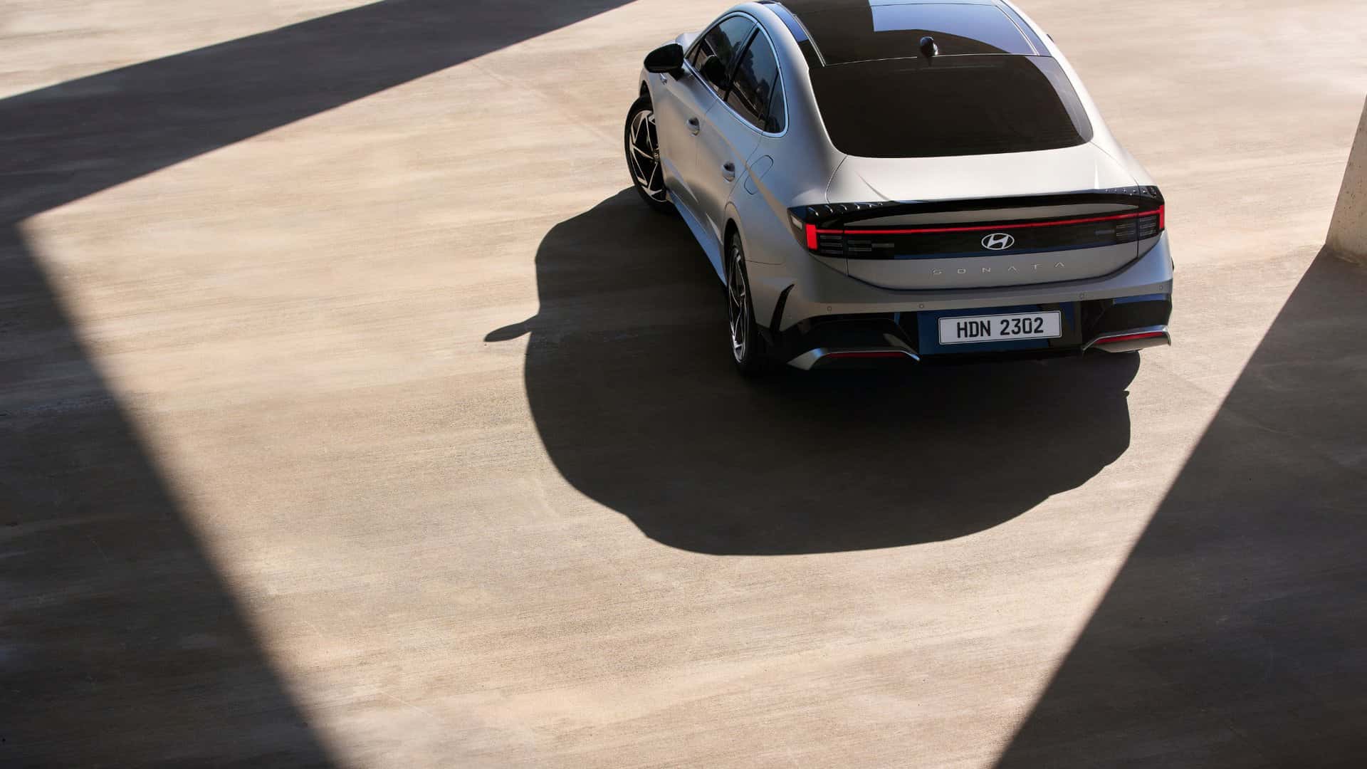 2026 Hyundai Sonata rear view with full width LED tail light bar in modern urban setting.