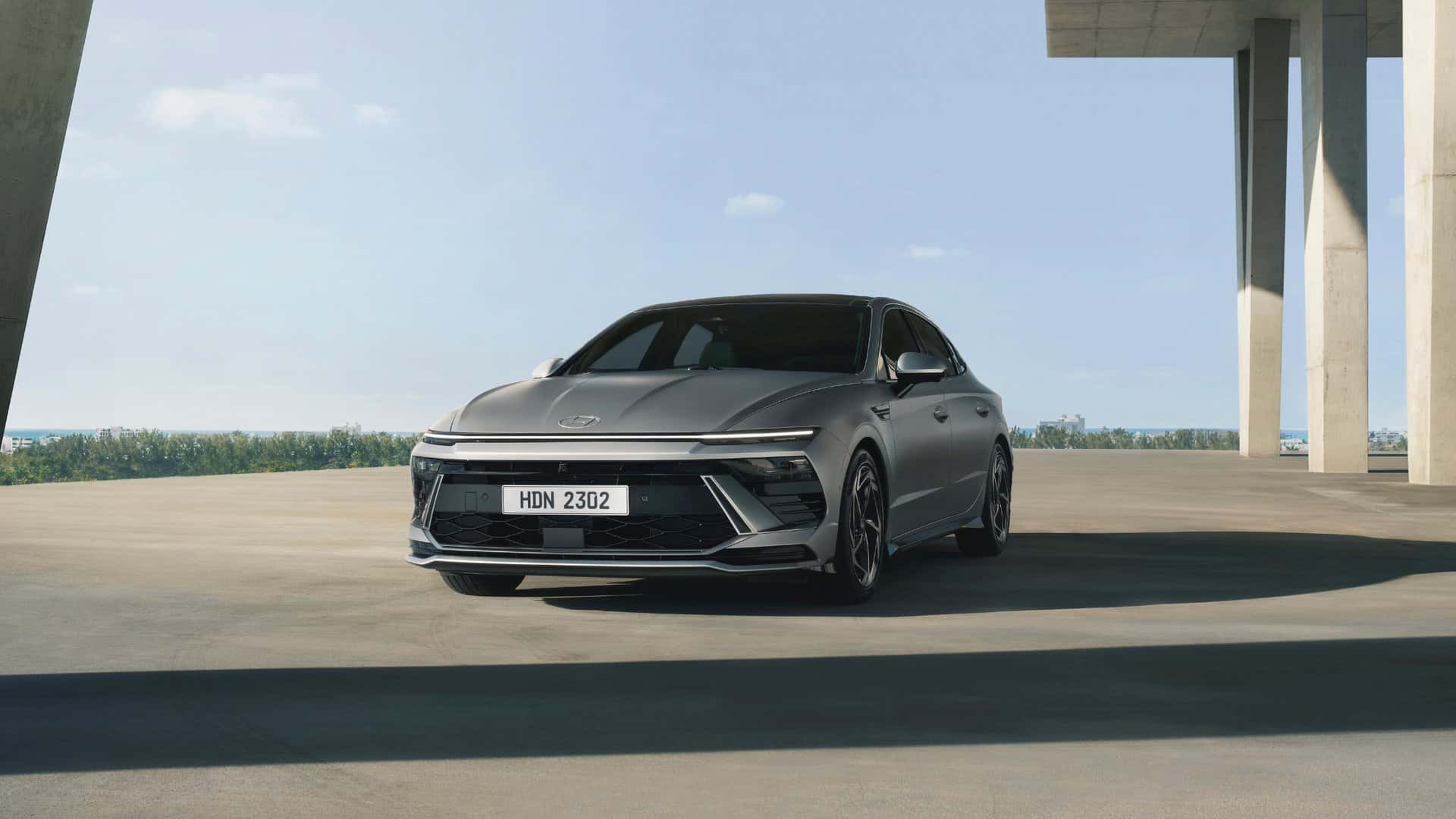 2026 Hyundai Sonata sedan driving through city street showcasing sleek aerodynamic exterior