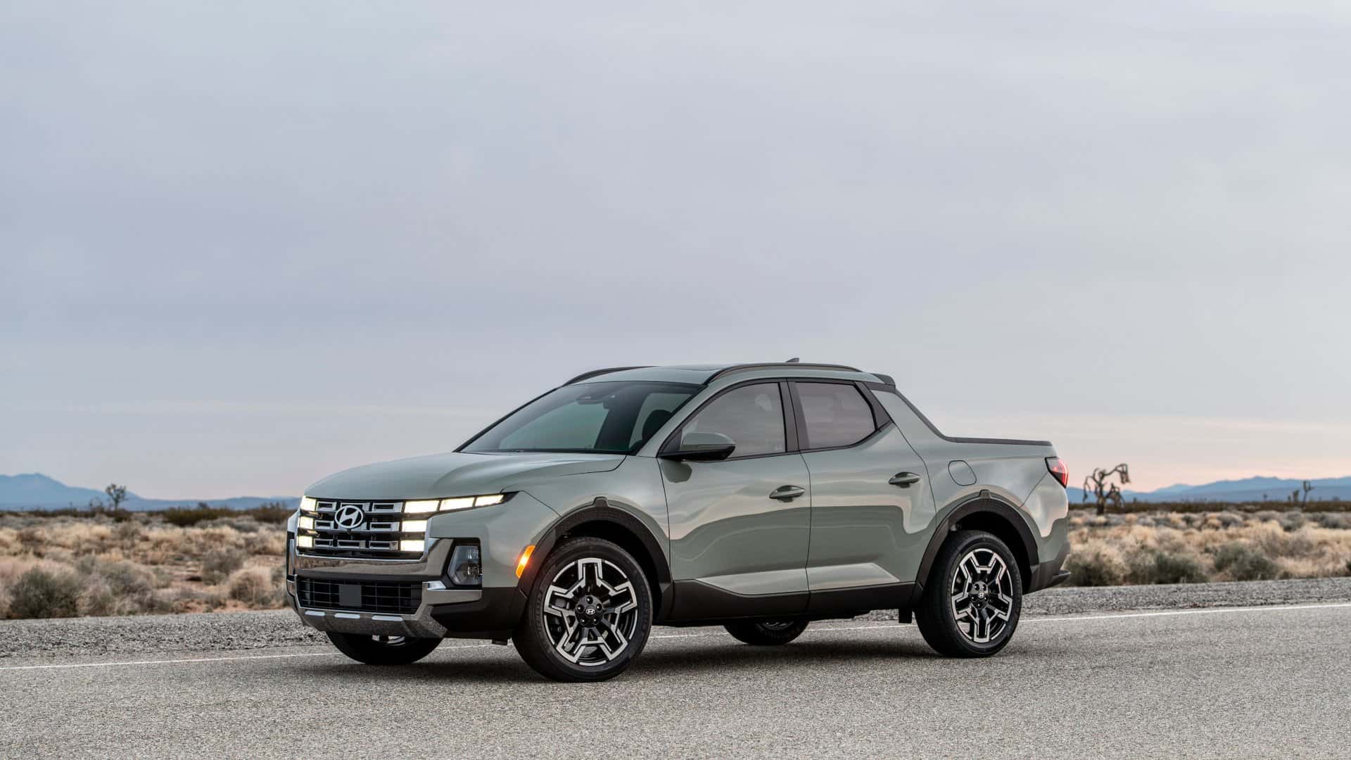 2026 Hyundai Santa Cruz pickup parked in front three quarter view on an open desert road.