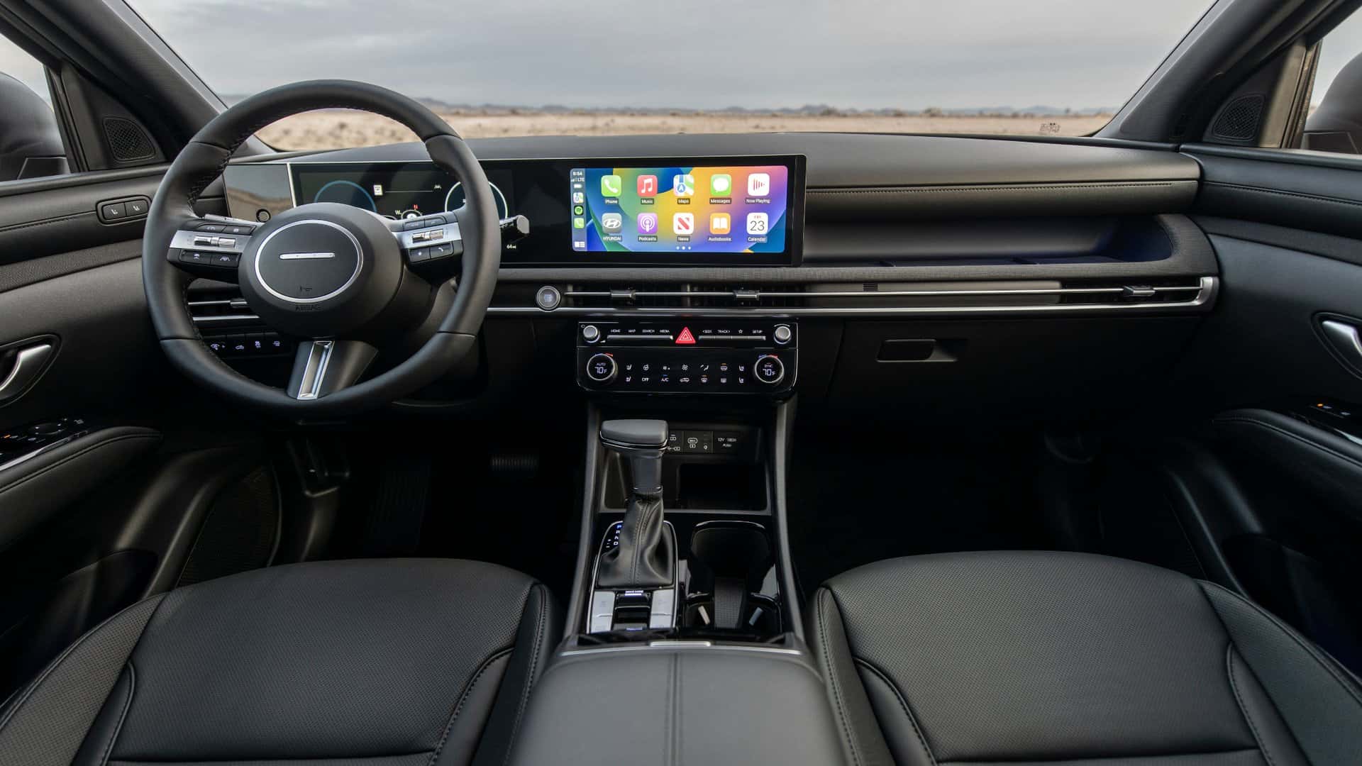 2026 Hyundai Santa Cruz interior dashboard with touchscreen display gear shifter and front seats.