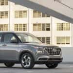 2026 Hyundai Venue compact SUV parked in front three quarter view in an urban parking deck.