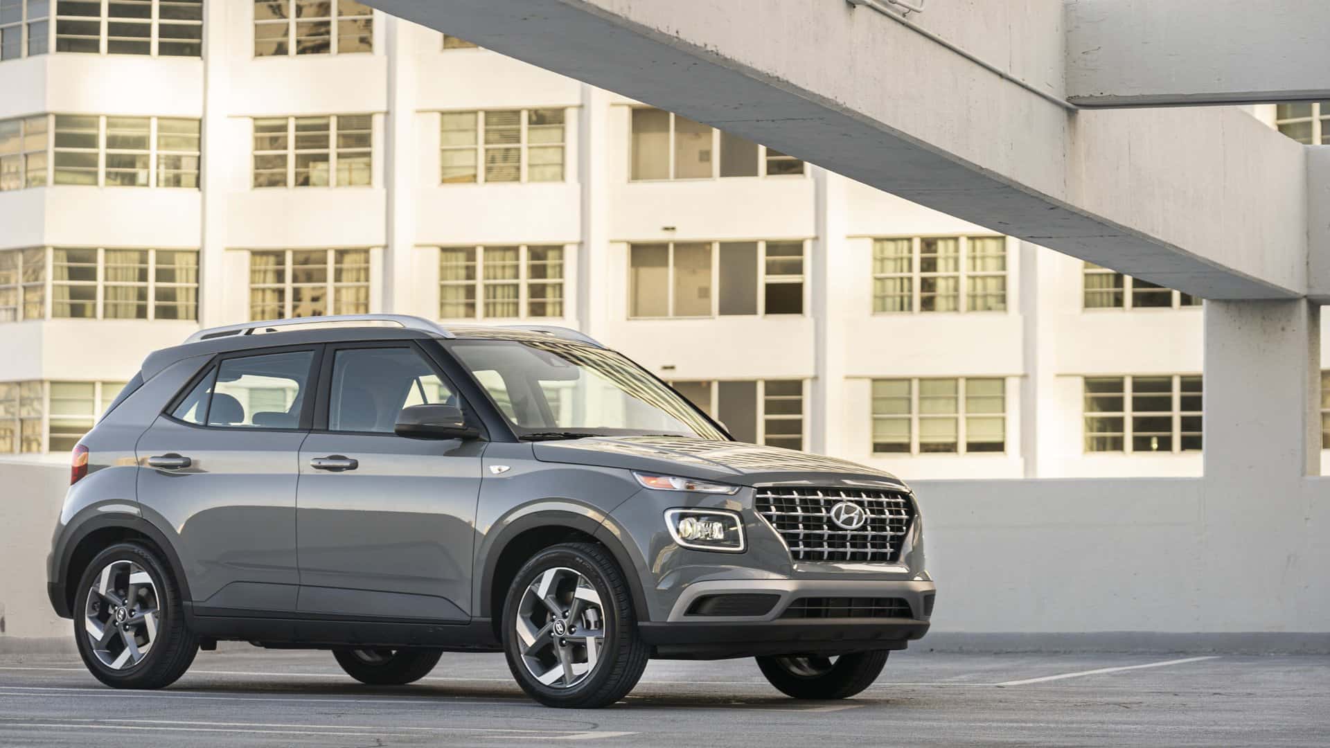 2026 Hyundai Venue compact SUV parked in front three quarter view in an urban parking deck.