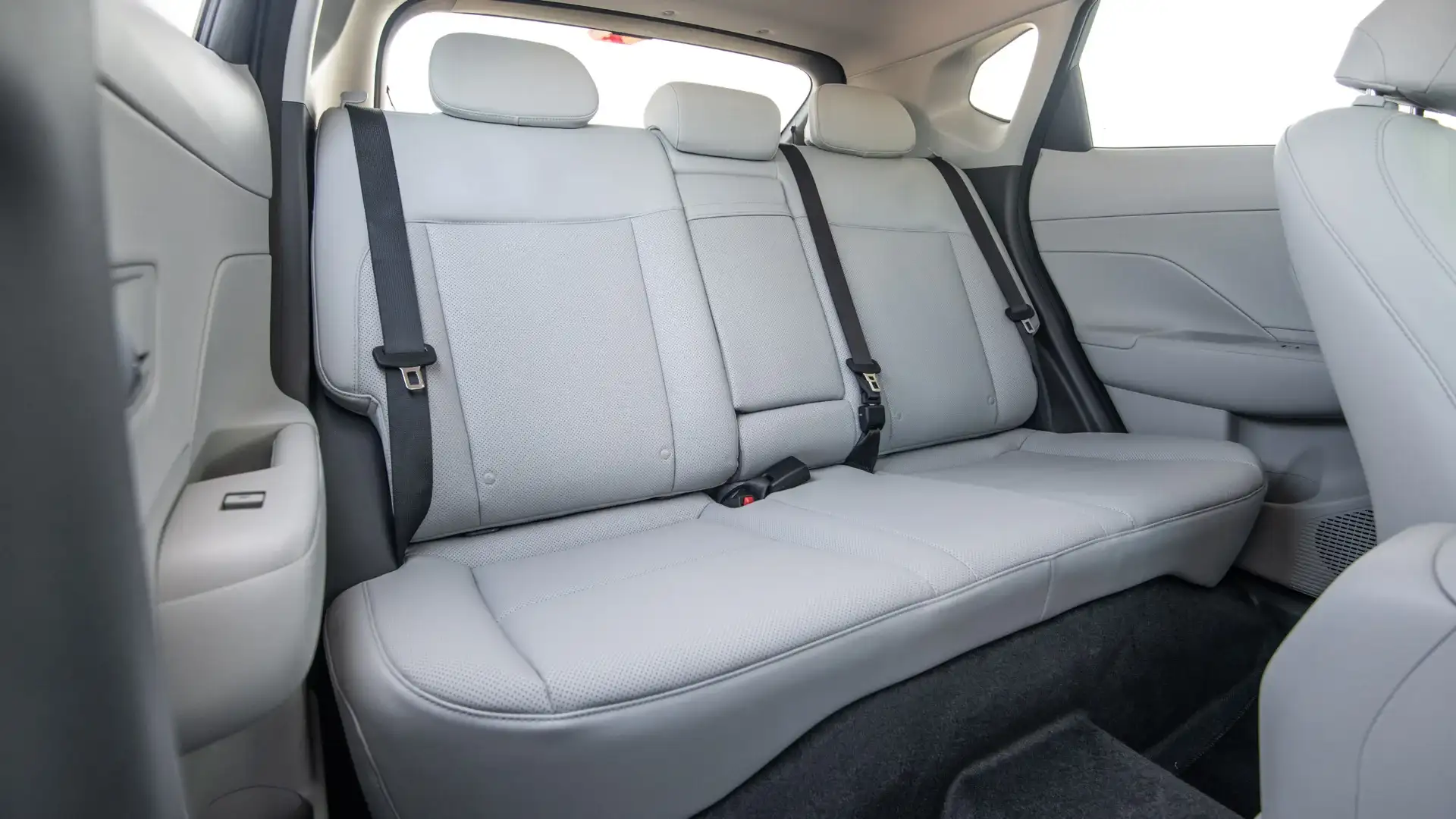 2026 Hyundai Kona rear bench seat with light upholstery, headrests, and three seatbelts.