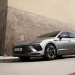 2026 Hyundai Sonata silver sedan parked on city street with side profile and modern LED lighting.