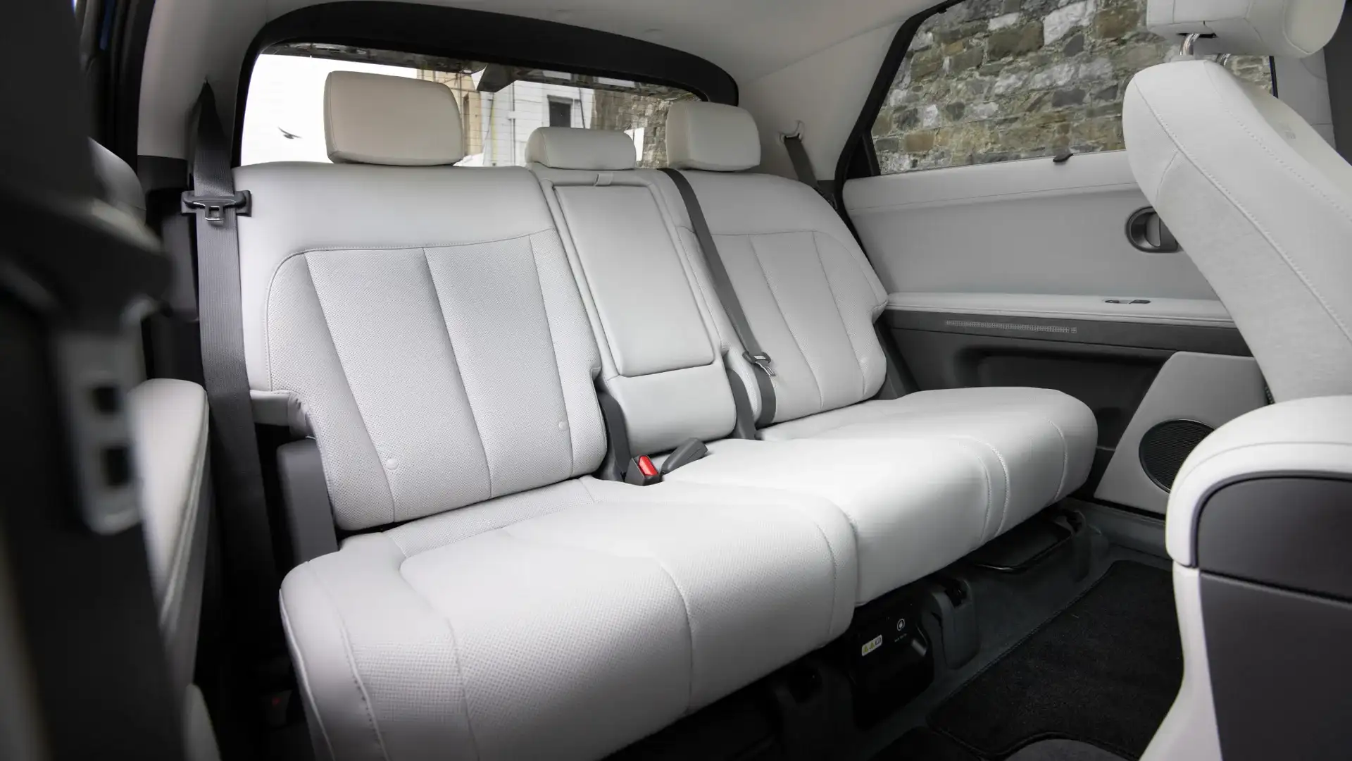 2026 Hyundai IONIQ 5 rear seating area with light upholstery, seatbelts, and spacious cabin layout.