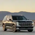2026 Hyundai Palisade black SUV parked in desert setting with bold grille and mountain backdrop.
