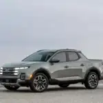 2026 Hyundai Santa Cruz gray sport adventure truck parked on desert road with rugged wheel design.