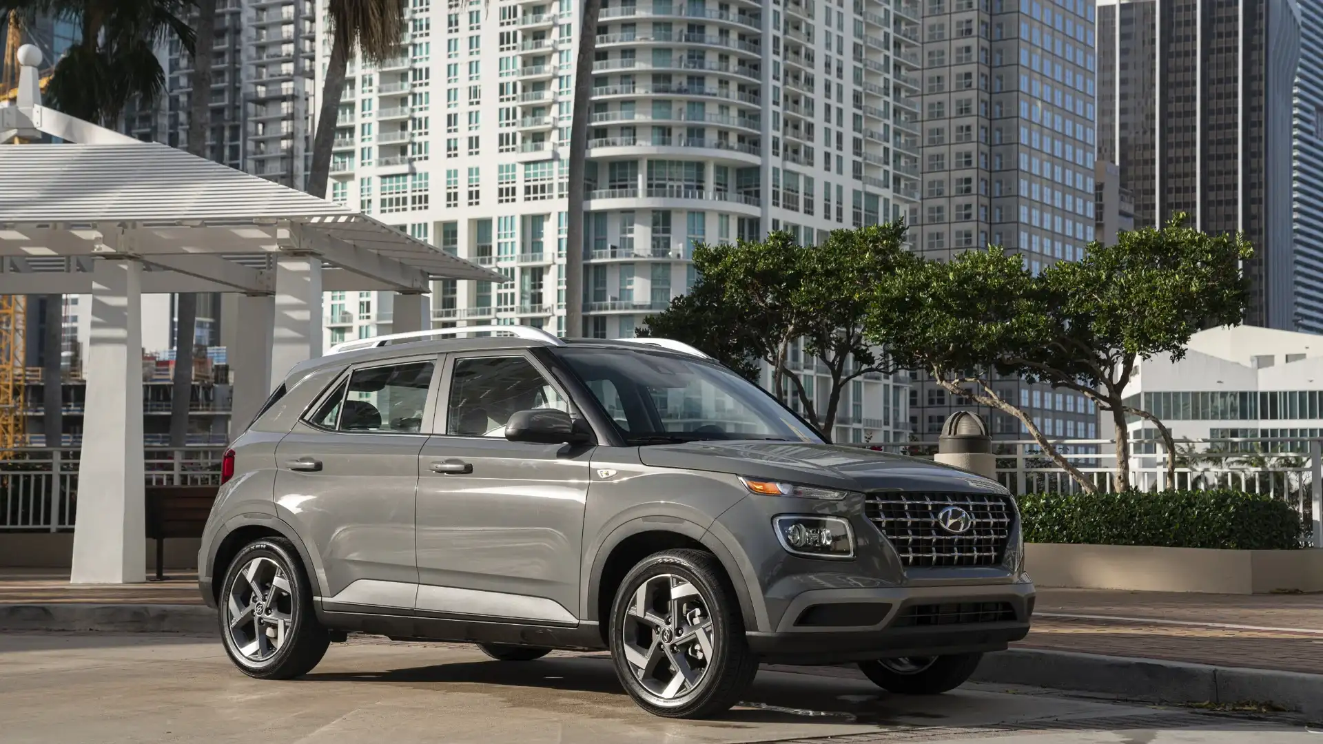 2026 Hyundai Venue gray compact SUV parked in urban setting with front grille and alloy wheels.