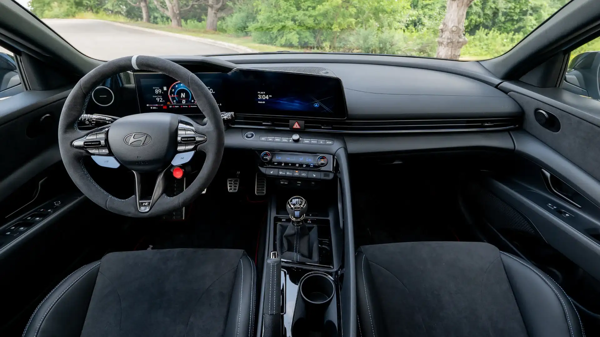 2026 Hyundai Elantra N cockpit with digital gauge cluster, manual shifter, and sport steering wheel.