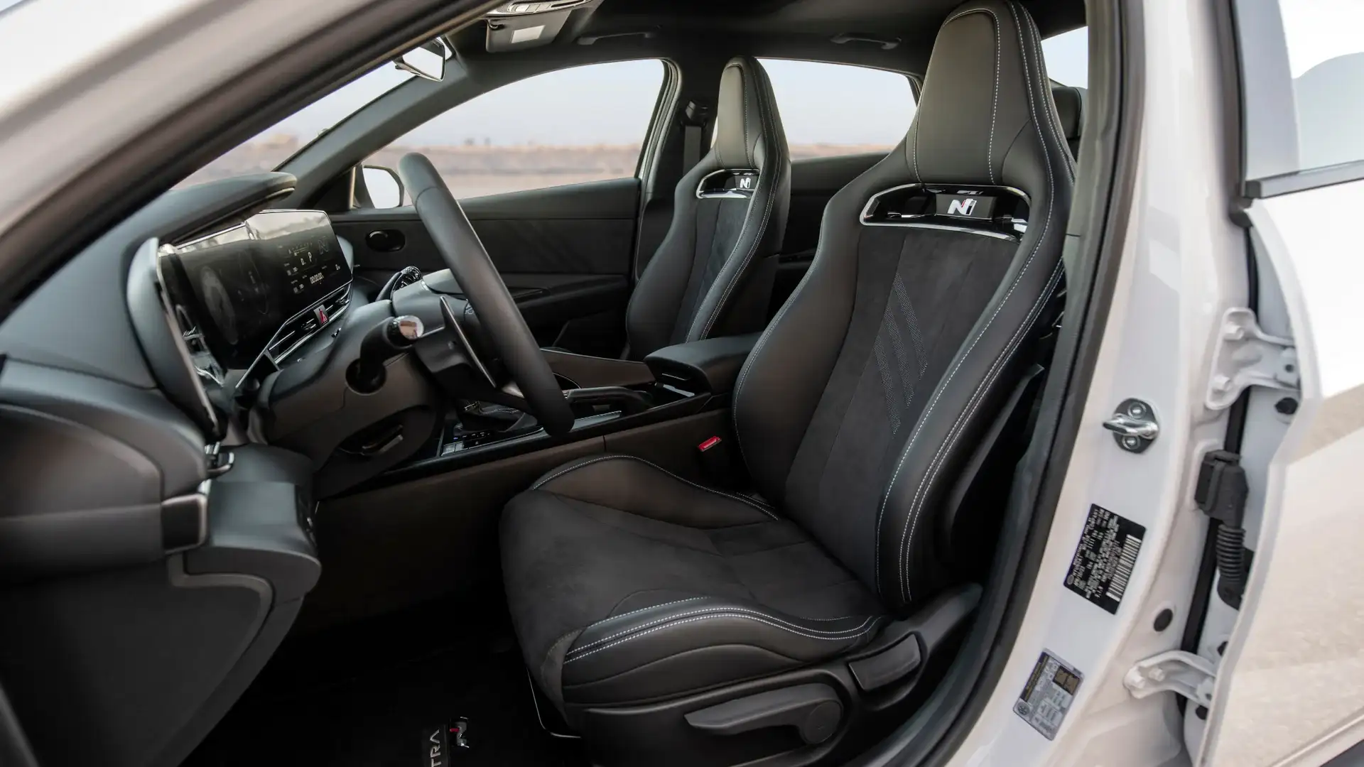 2026 Hyundai Elantra N interior with black sport bucket seats, N logos, and suede seat inserts.