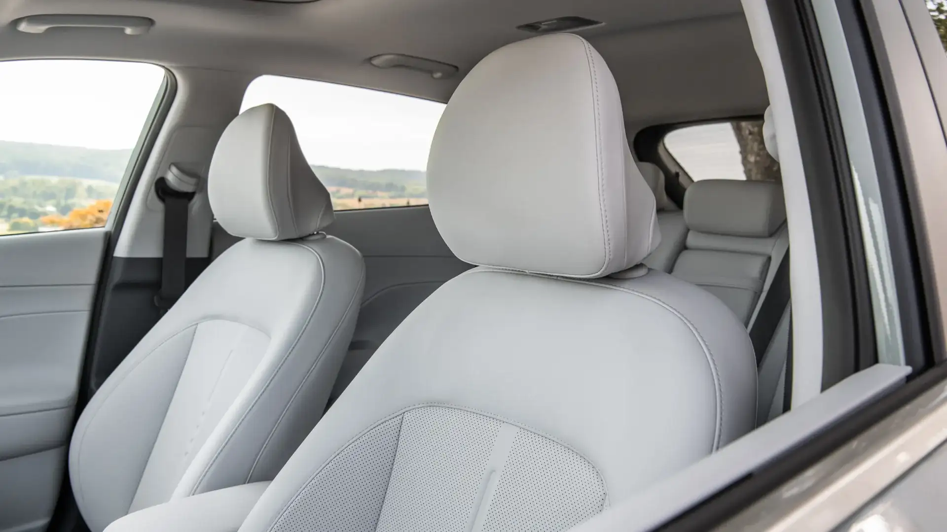 2026 Hyundai Kona cabin with light front seats and rear seating visible through open side window.