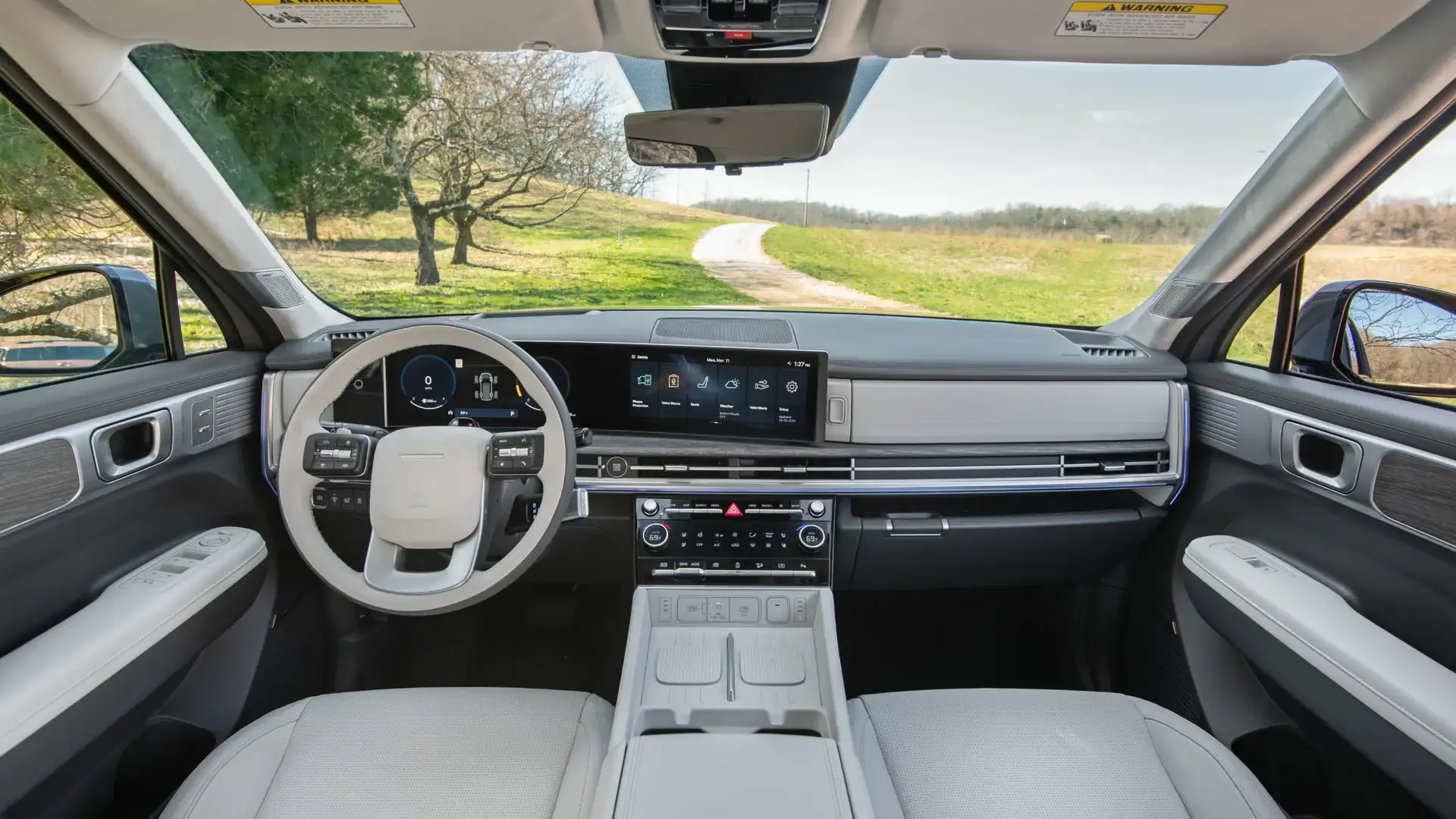 2026 Hyundai Santa Fe dashboard with digital display, light interior, and countryside view.