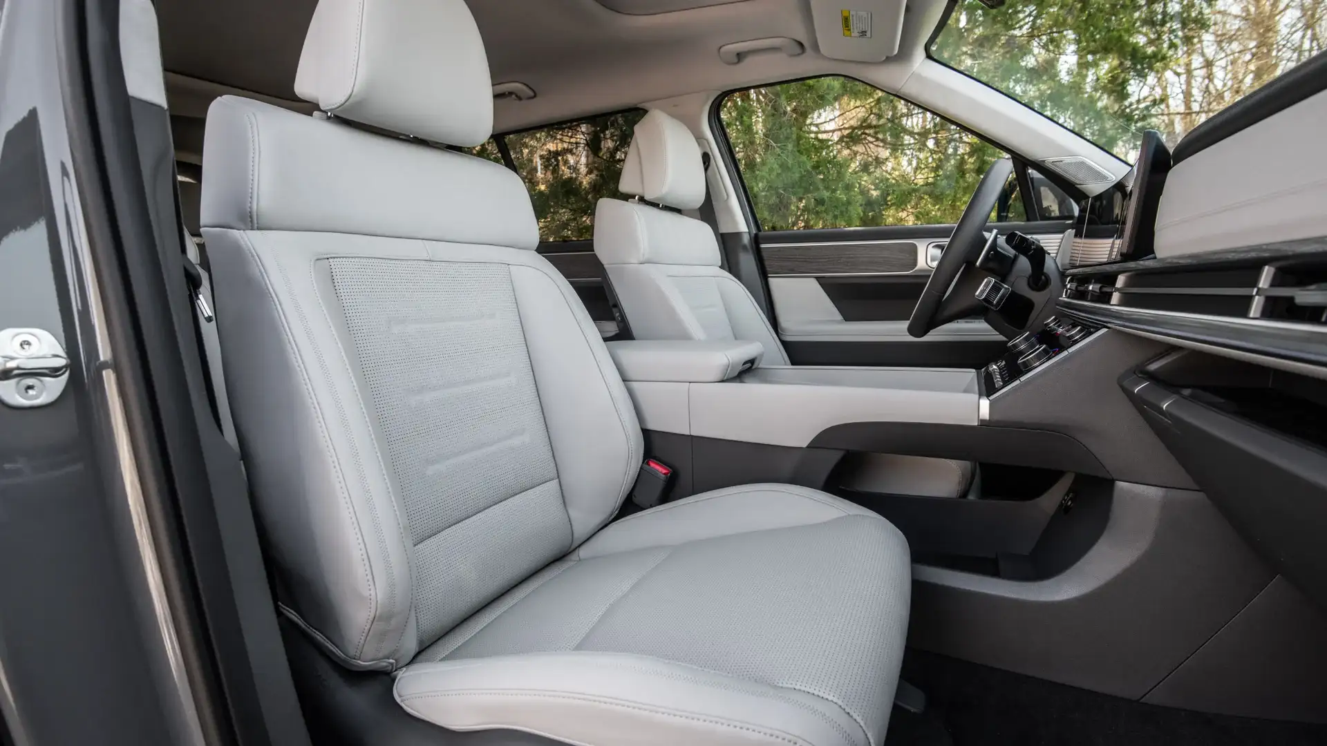 2026 Hyundai Santa Fe front cabin with light seats, wide dashboard, and open passenger door view.