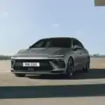 2026 Hyundai Sonata gray sedan parked under modern concrete structure with slim LED front lighting.