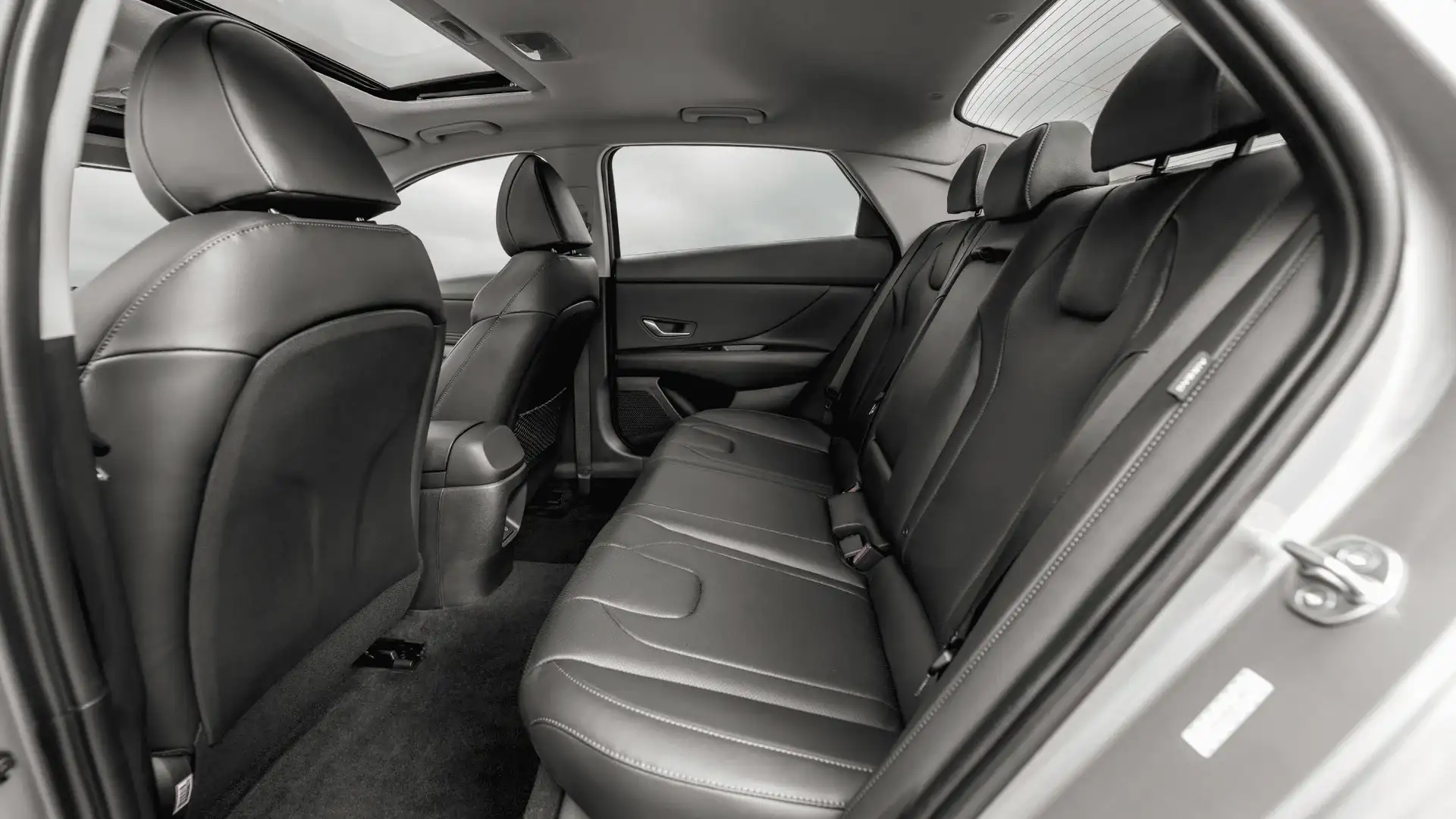 2026 Hyundai Elantra rear cabin with black leather seats, seatbelts, and open sunroof.