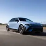 2026 Hyundai IONIQ 5 N blue electric SUV driving on racetrack with black wheels and red trim.