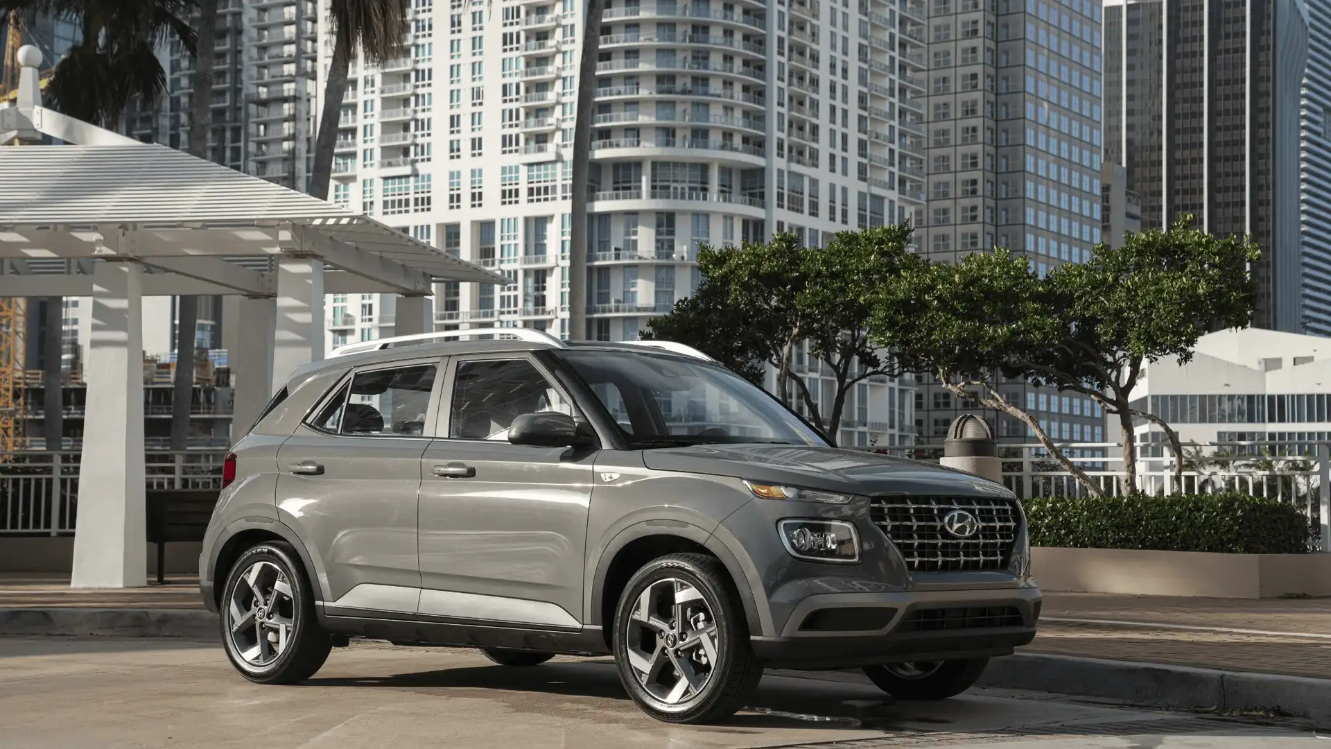 2026 Hyundai Venue gray compact SUV parked in city setting with roof rails and alloy wheels.