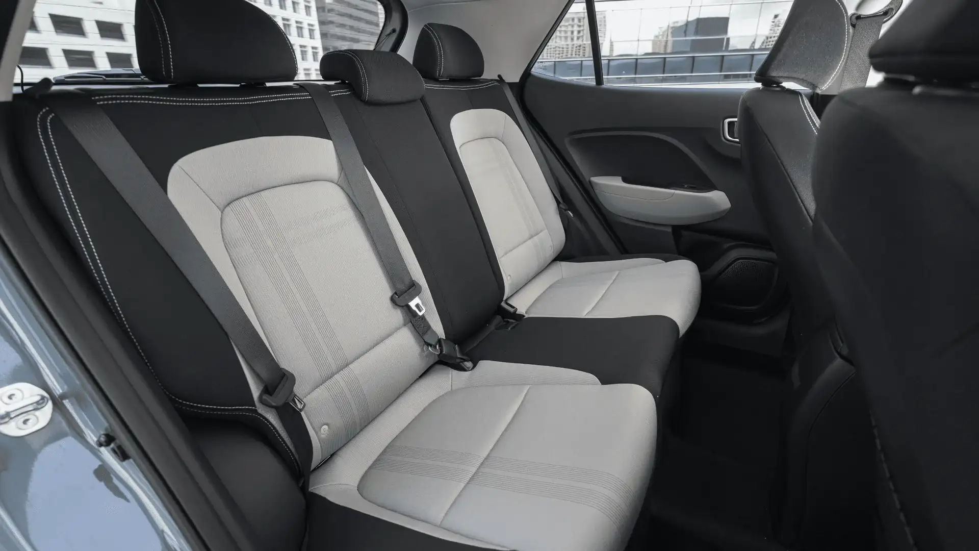 2026 Hyundai Venue rear cabin with two-tone seats, seatbelts, and compact interior layout.