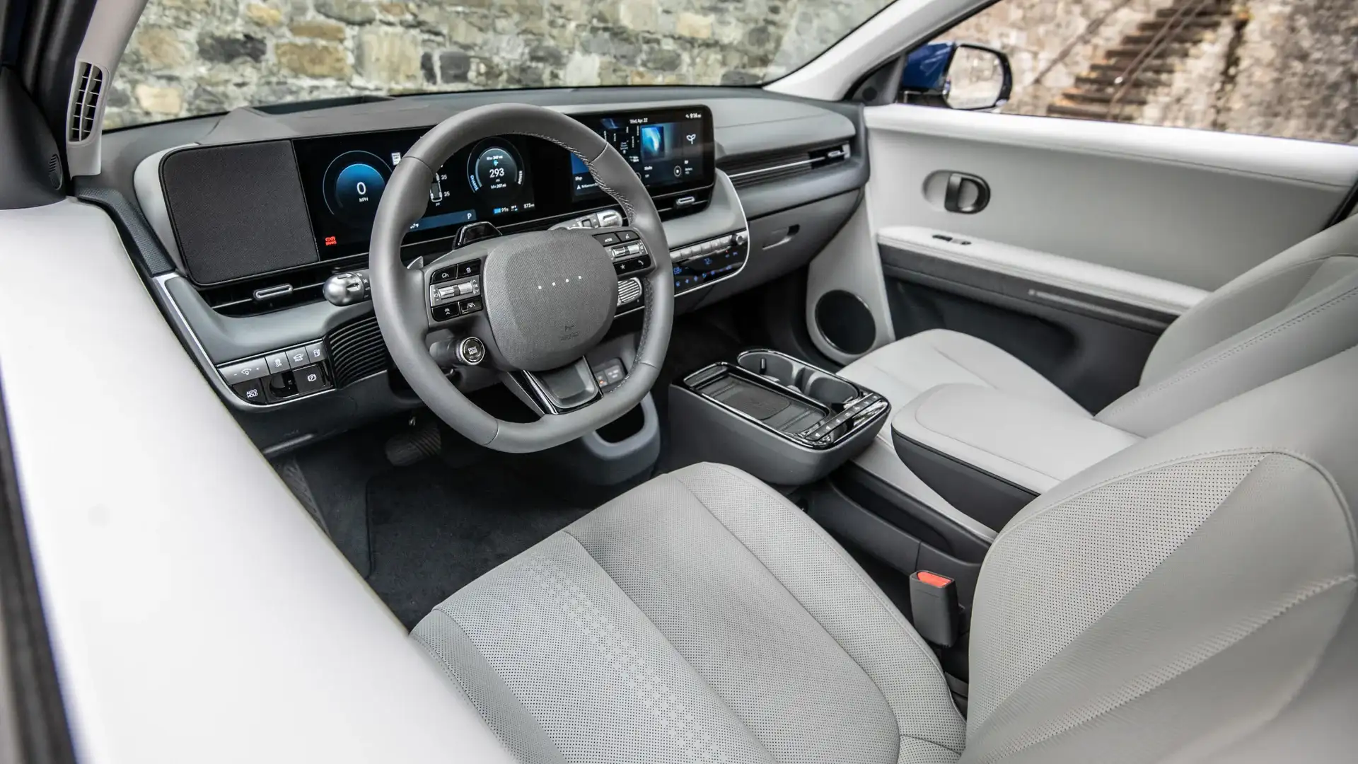 2027 Hyundai IONIQ 5 interior with light gray seats, digital display, steering wheel, and console.