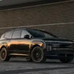 2027 Hyundai IONIQ 9 black electric SUV parked near modern building with LED daytime running lights.