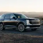 2027 Hyundai Palisade black SUV parked on mountain road at sunset with chrome grille.