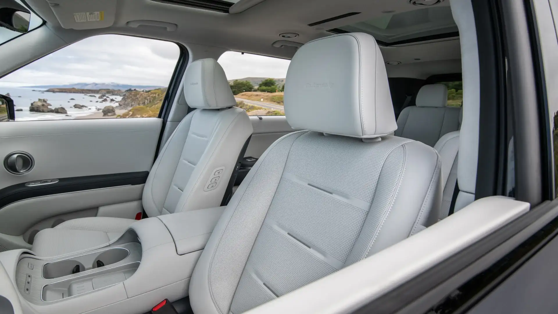 2027 Hyundai Palisade front interior with light leather seats, center console, and sunroof.