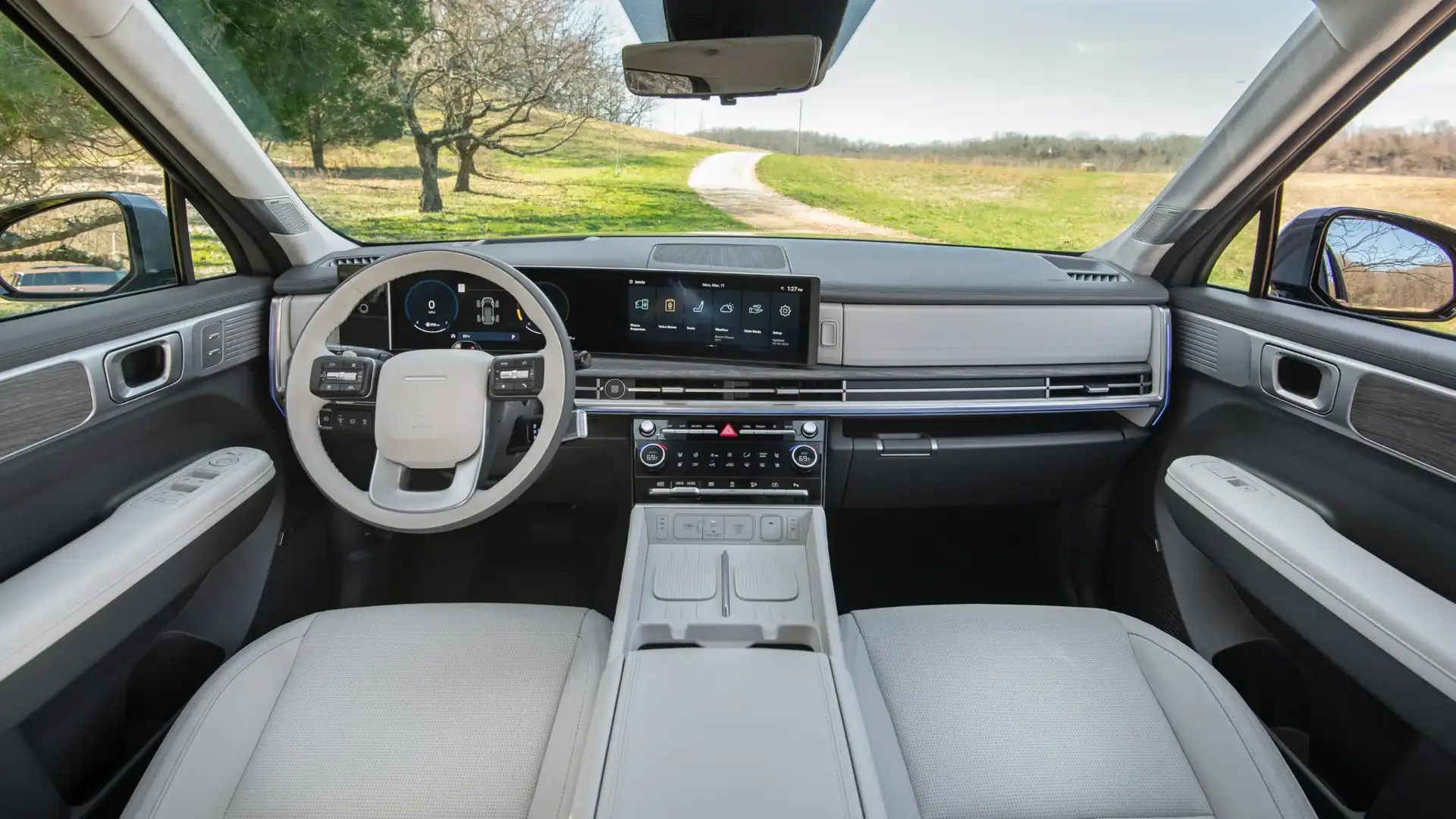2027 Hyundai Santa Fe interior with wide digital display, light dashboard, and open road view.
