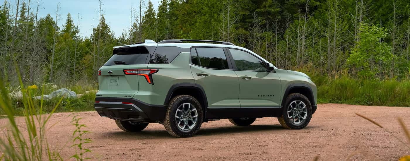 Rear view of a green 2025 Chevy Equinox ACTIV parked off-road.