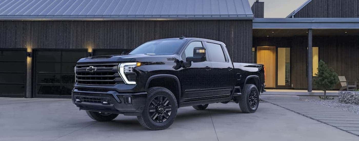 A black 2025 Chevy Silverado 2500 HD High Country is shown from the front at an angle.