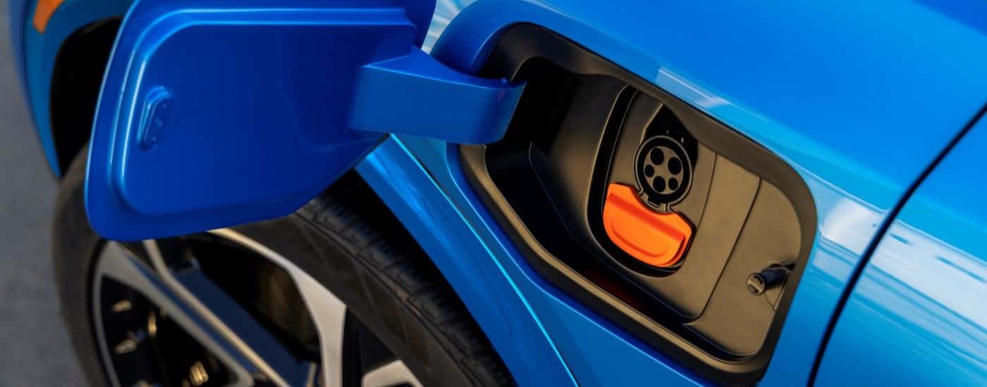 A close-up on the charging outlet of a blue 2024 Chevy Equinox EV 3LT.