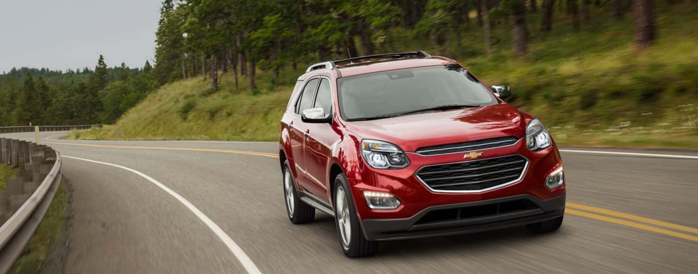 A red 2016 Chevy Equinox is driving to a Chevy dealer near Atkinson.