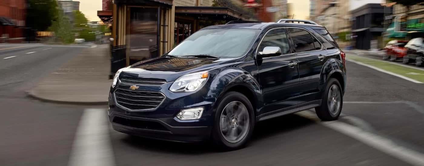 A dark blue 2017 Chevy Equinox is driving to a Chevy dealer near Salem.