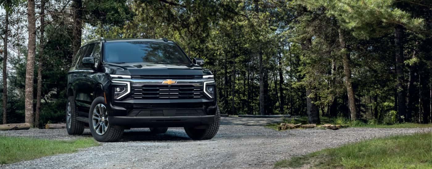 A black 2025 Chevy Tahoe is parked on a gravel lot.