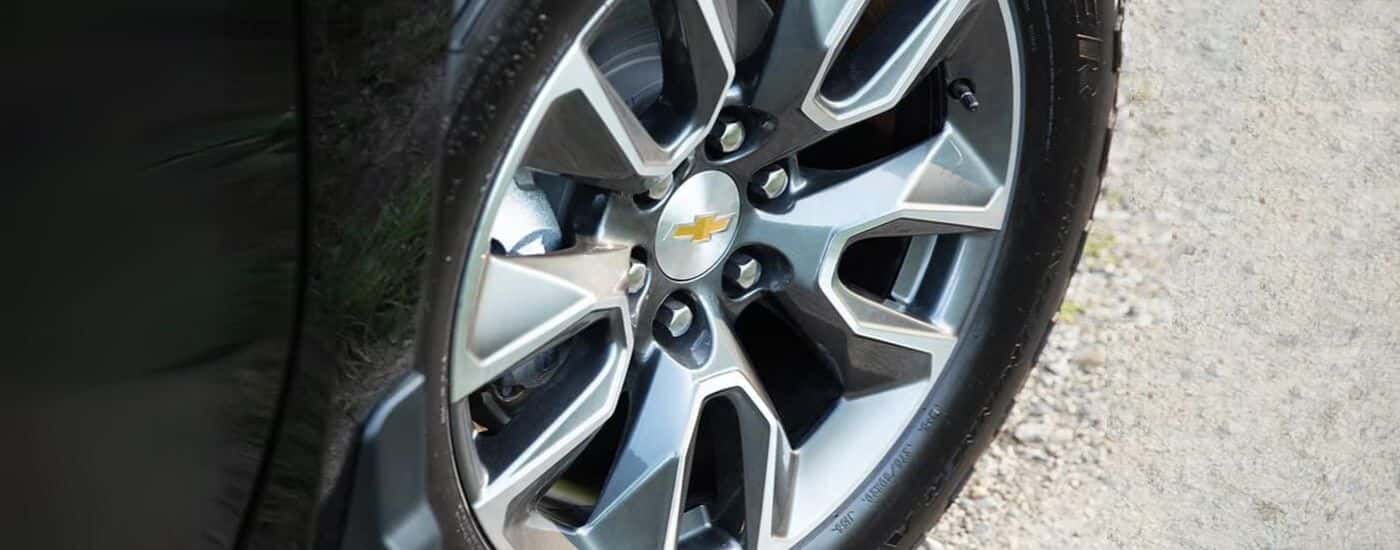 A close-up shows a silver wheel on a black 2024 Chevy Silverado 1500.