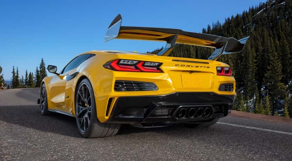 A yellow 2025 Chevy Corvette ZR1 parked on a tree-lined road.